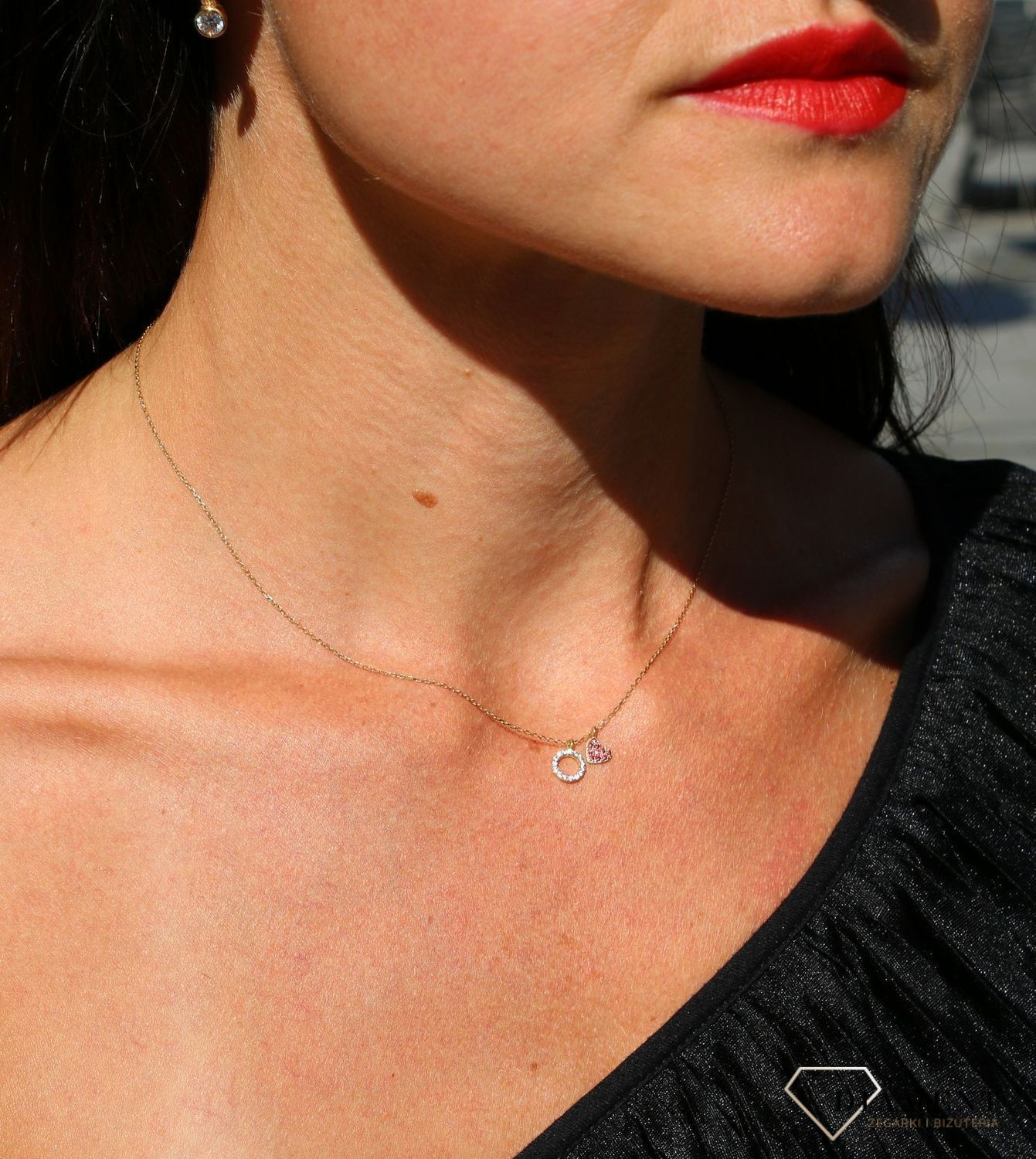Delikatny naszyjnik celebrytka  próby 333 skomponowany ze złotego łańcuszka i dwóch zawieszek - serca z cyrkoniami w kolorze czerwonym oraz kółeczka z cyrkoniami w kolorze białym to wyjątkowa biżuteria inspirowana ws.jpg