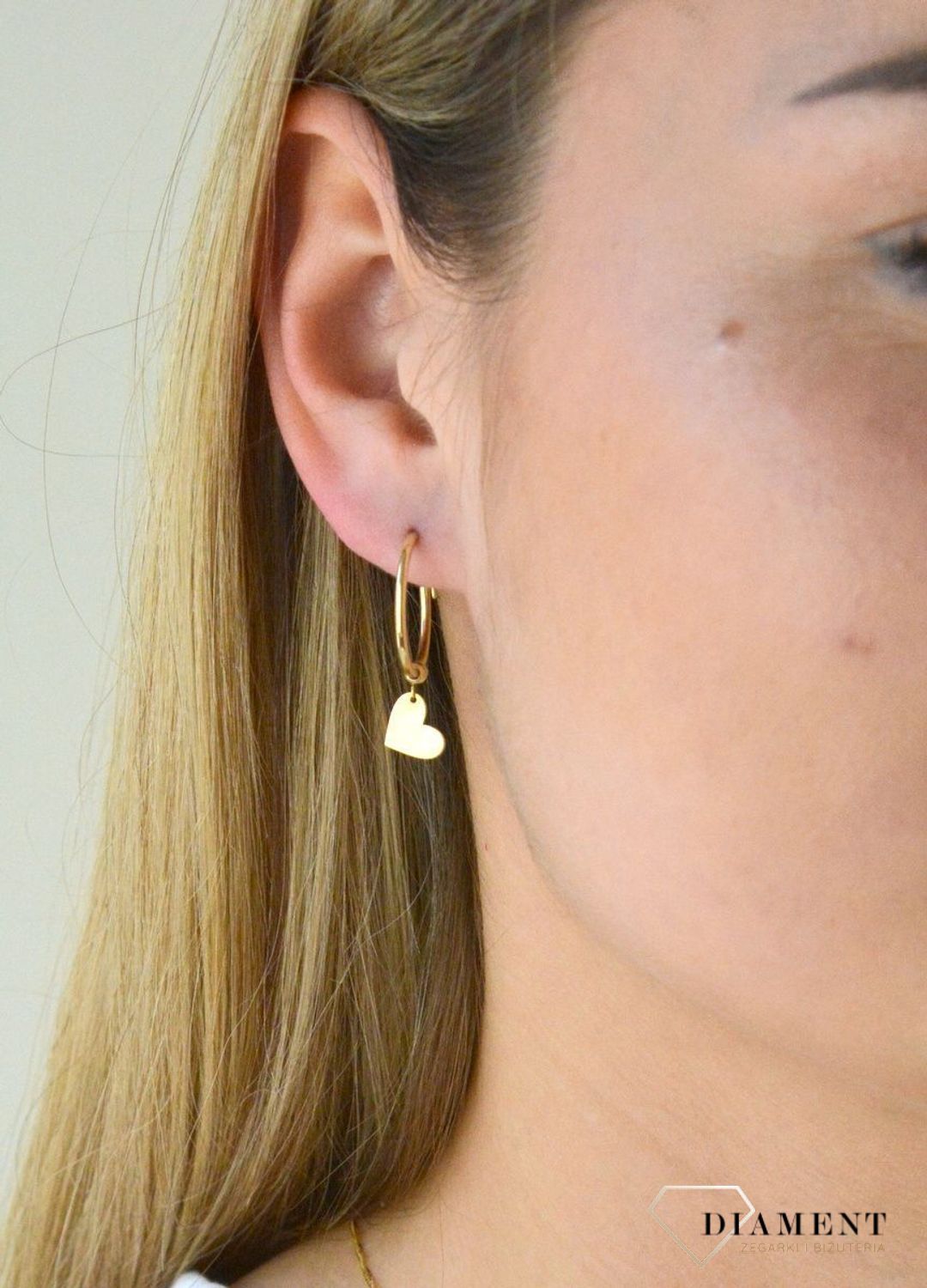Kolczyki złote kółka z serduszkiem ZW-X-000-N00-HA18585. Eleganckie, złote kolczyki gładki owal wykonane z próby złota 333 o wadze około 1,20 g oraz długości około 3 cm. Kolczyki koła zostały ozdobione wiszącym serduszkiem.jpg