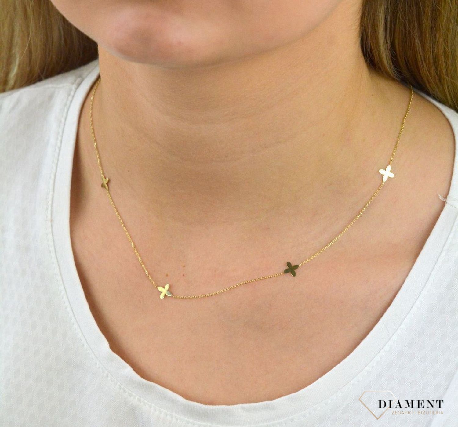 Złota celebrytka próby 333 z elementami w kształcie kwiatków ZW-X-000-N45-CA18538. Wykonana ze 8-karatowego żółtego złota, próba 333. Wzór z żółtego złota łączy subtelność łańcuszka z harmonią kształtu kwiatków..png