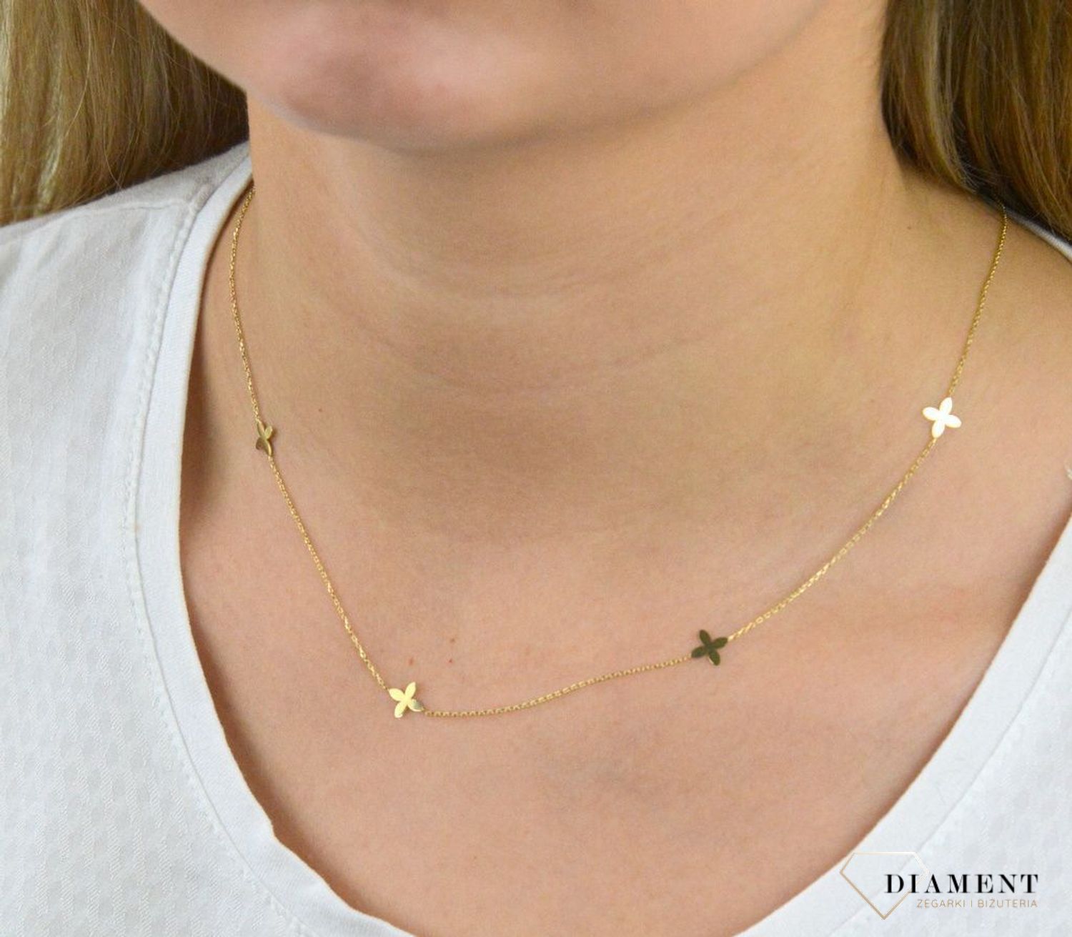 Złota celebrytka próby 333 z elementami w kształcie kwiatków ZW-X-000-N45-CA18538. Wykonana ze 8-karatowego żółtego złota, próba 333. Wzór z żółtego złota łączy subtelność łańcuszka z harmonią kształtu kwiatków..png