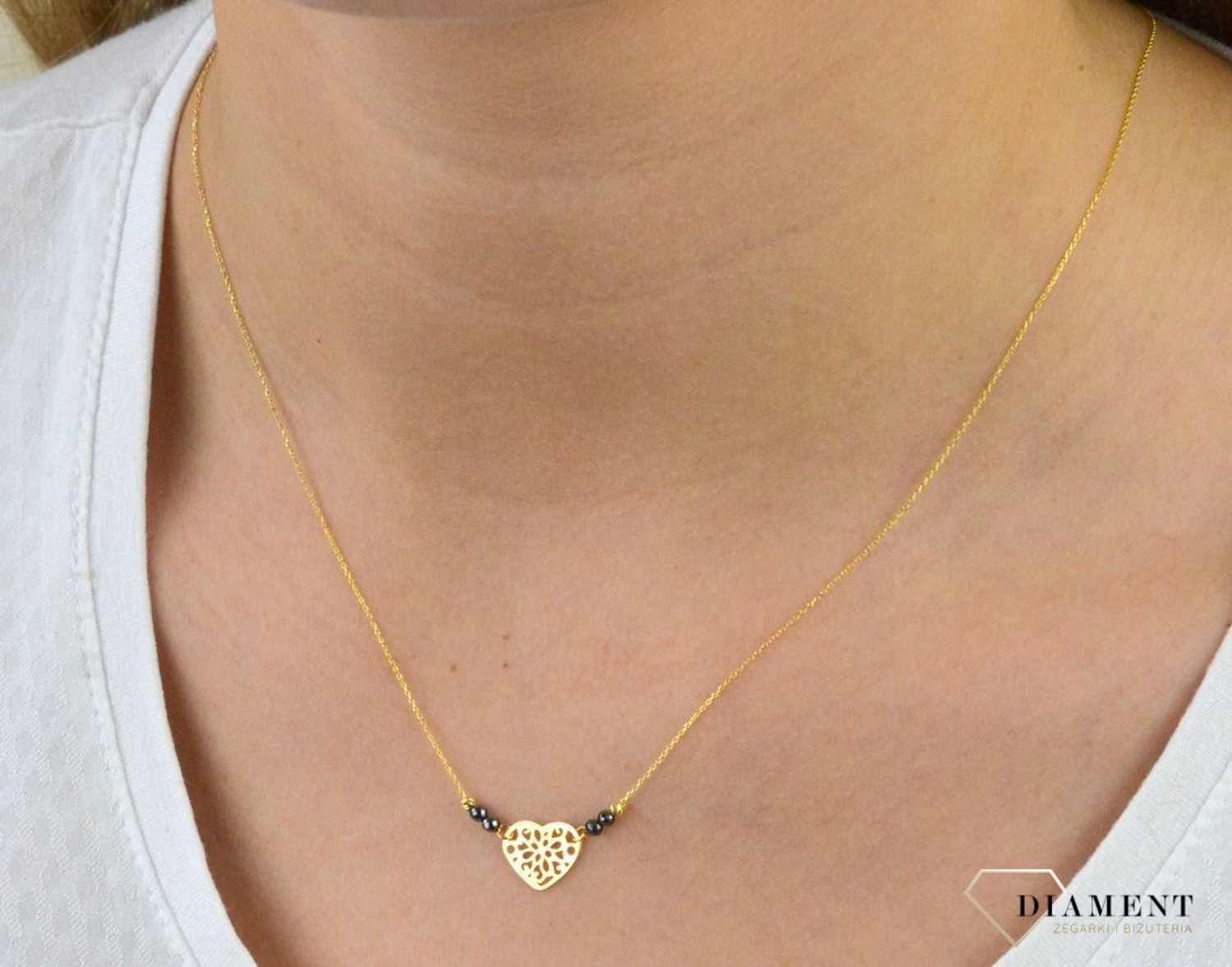 Złoty naszyjnik celebrytka próby 333 serce ZW-X-X09-N42-CW17835 .Złoty naszyjnik celebrytka z elementem ozdobnym w postaci serca ozdobione po obu stronach kuleczkami czarnymi oraz złotymi. .png