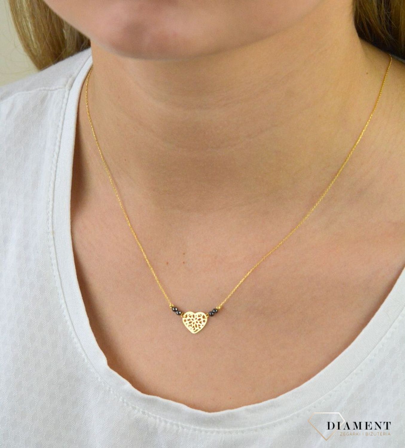 Złoty naszyjnik celebrytka próby 333 serce ZW-X-X09-N42-CW17835 .Złoty naszyjnik celebrytka z elementem ozdobnym w postaci serca ozdobione po obu stronach kuleczkami czarnymi oraz złotymi. .png