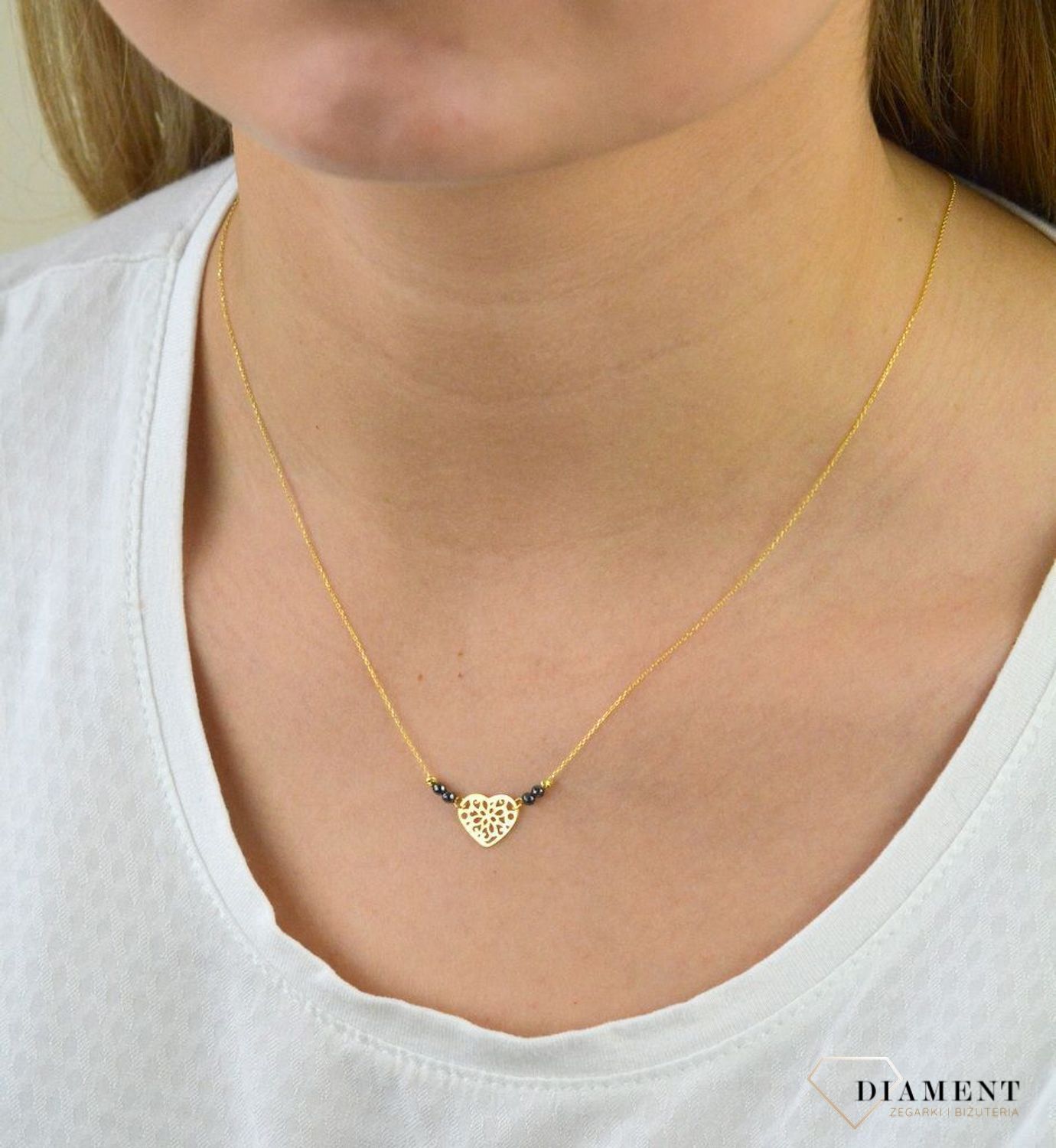 Złoty naszyjnik celebrytka próby 333 serce ZW-X-X09-N42-CW17835 .Złoty naszyjnik celebrytka z elementem ozdobnym w postaci serca ozdobione po obu stronach kuleczkami czarnymi oraz złotymi. .png