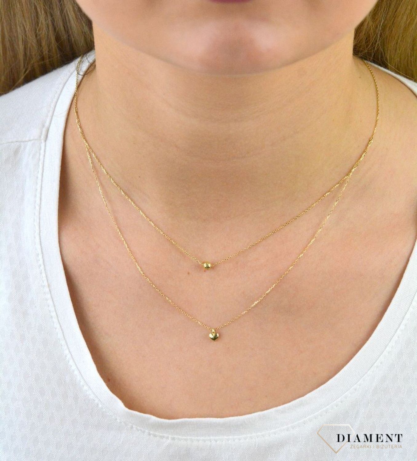 Złoty naszyjnik próby 333 serce z kuleczką ZW-X-X09-N45-CA18582. Złoty naszyjnik celebrytka warstwowa z elementami ozdobnym w postaci serca i kulki. Wykonana ze 8-karatowego żółtego złota, próba 333.png