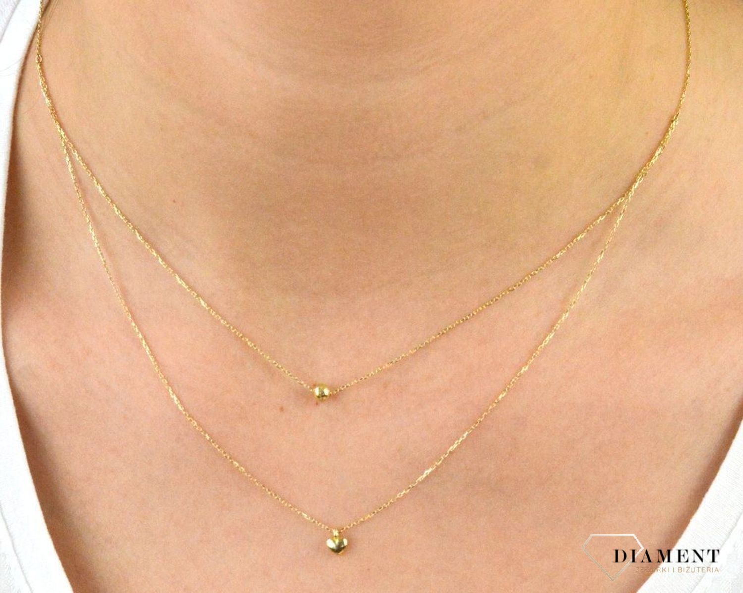 Złoty naszyjnik próby 333 serce z kuleczką ZW-X-X09-N45-CA18582. Złoty naszyjnik celebrytka warstwowa z elementami ozdobnym w postaci serca i kulki. Wykonana ze 8-karatowego żółtego złota, próba 333.png