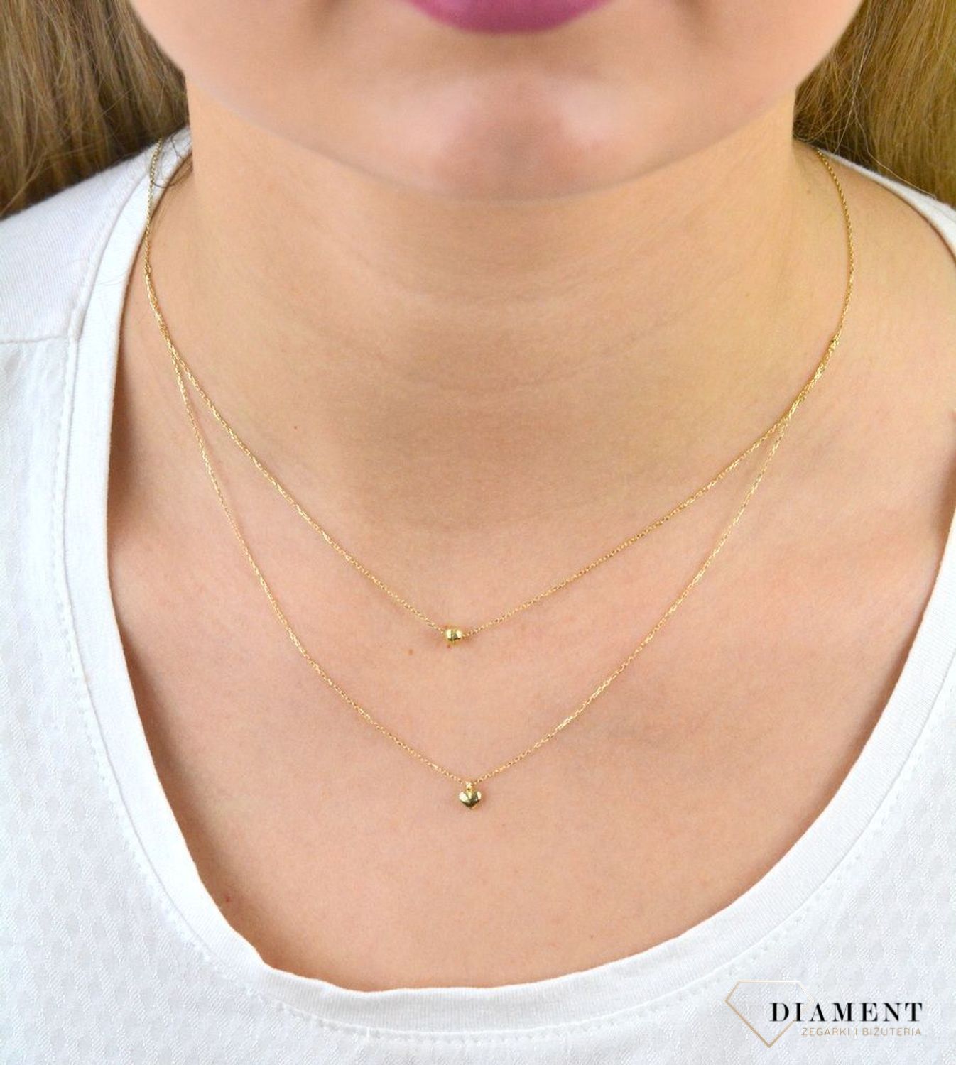 Złoty naszyjnik próby 333 serce z kuleczką ZW-X-X09-N45-CA18582. Złoty naszyjnik celebrytka warstwowa z elementami ozdobnym w postaci serca i kulki. Wykonana ze 8-karatowego żółtego złota, próba 333.png