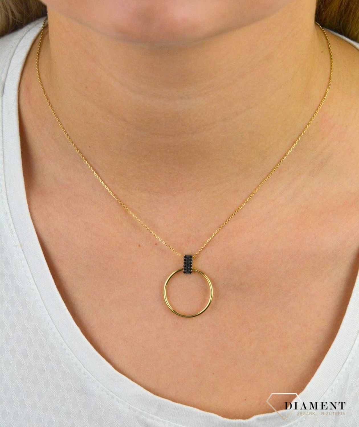 Złoty naszyjnik celebrytka próby 333 z elementem ozdobnym ZW-X-X09-N50-CA18539. Złoty naszyjnik celebrytka  z elementem ozdobnym w postaci koła z czarnymi cyrkoniami. Wykonana ze 8-karatowego żółtego złota, próba 333.png