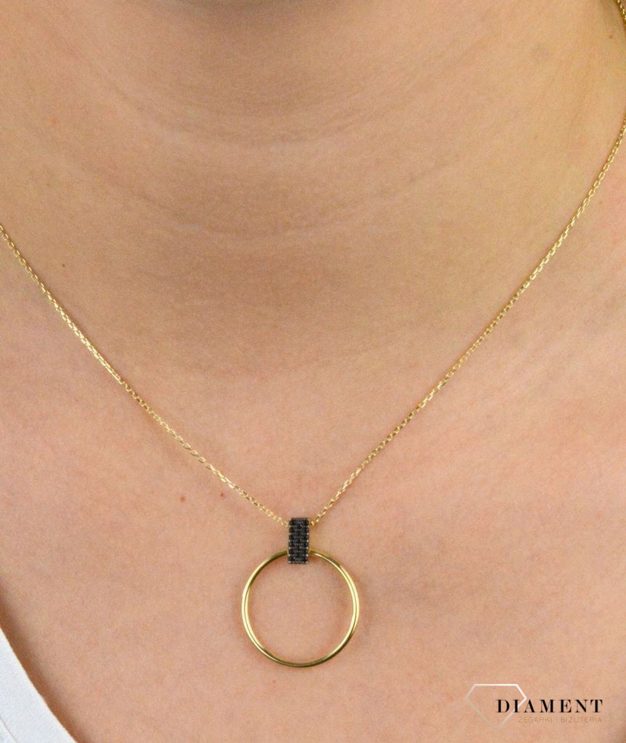 Złoty naszyjnik celebrytka próby 333 z elementem ozdobnym ZW-X-X09-N50-CA18539. Złoty naszyjnik celebrytka  z elementem ozdobnym w postaci koła z czarnymi cyrkoniami. Wykonana ze 8-karatowego żółtego złota, próba 333.png