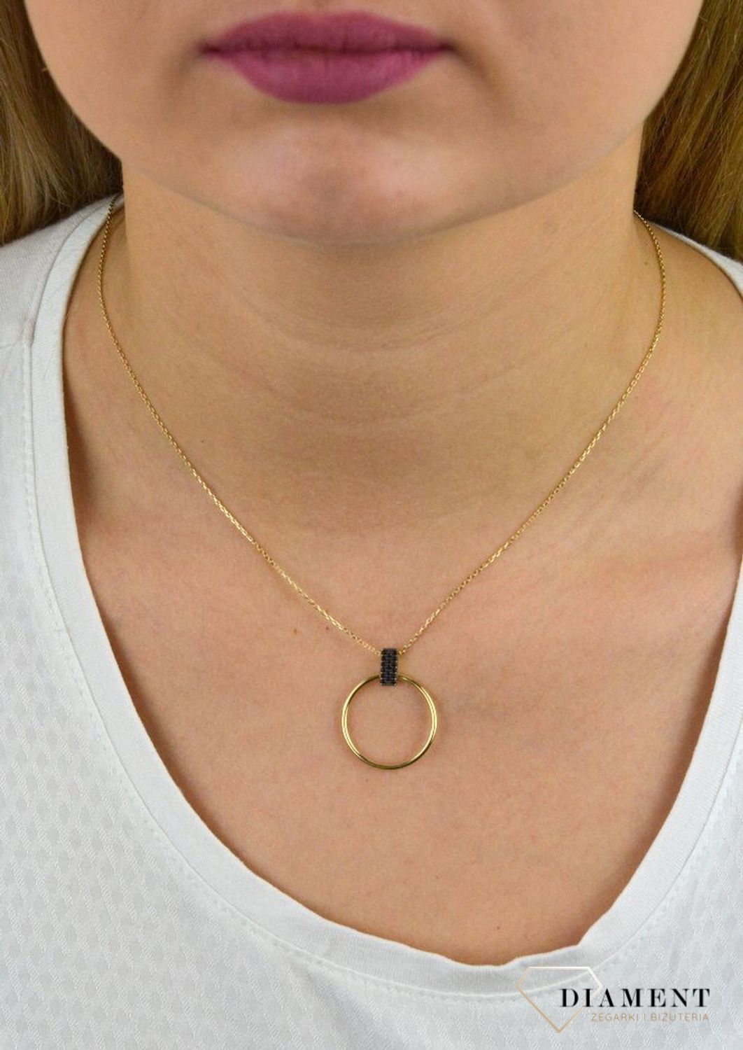 Złoty naszyjnik celebrytka próby 333 z elementem ozdobnym ZW-X-X09-N50-CA18539. Złoty naszyjnik celebrytka  z elementem ozdobnym w postaci koła z czarnymi cyrkoniami. Wykonana ze 8-karatowego żółtego złota, próba 333.png